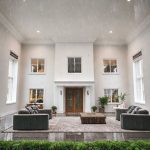 Modern six-bedroom Perth home under gentle rainfall, showcasing a fresh coat of paint on its sleek, professional exterior, ideal for featured images on painting cost topics.